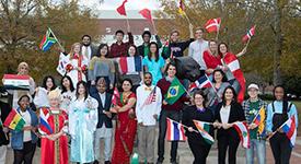 International Students holding flags in front of Mitchell Center